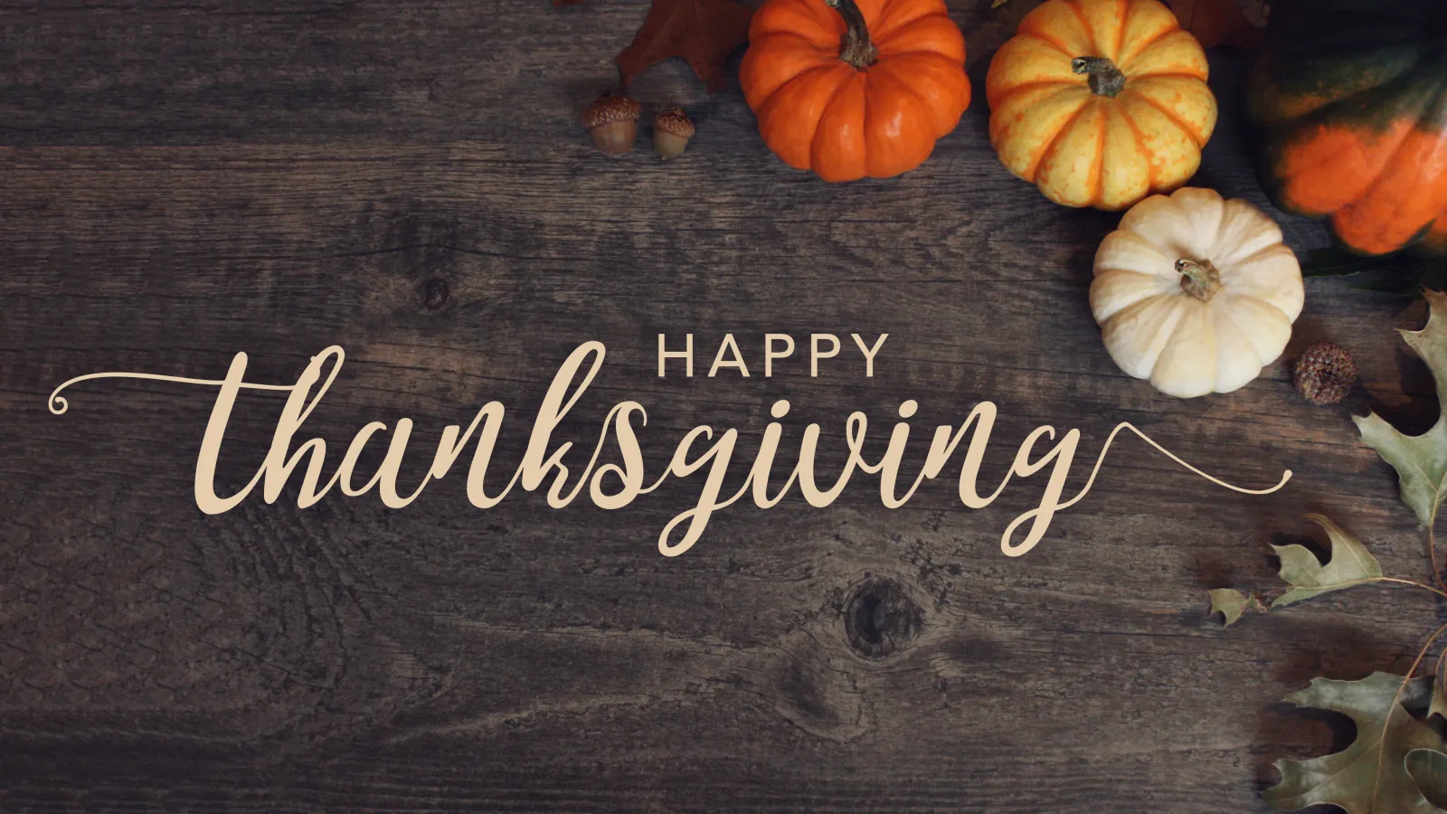 Happy Thanksgiving - variety of pumpkins and oak leaves on walnut board