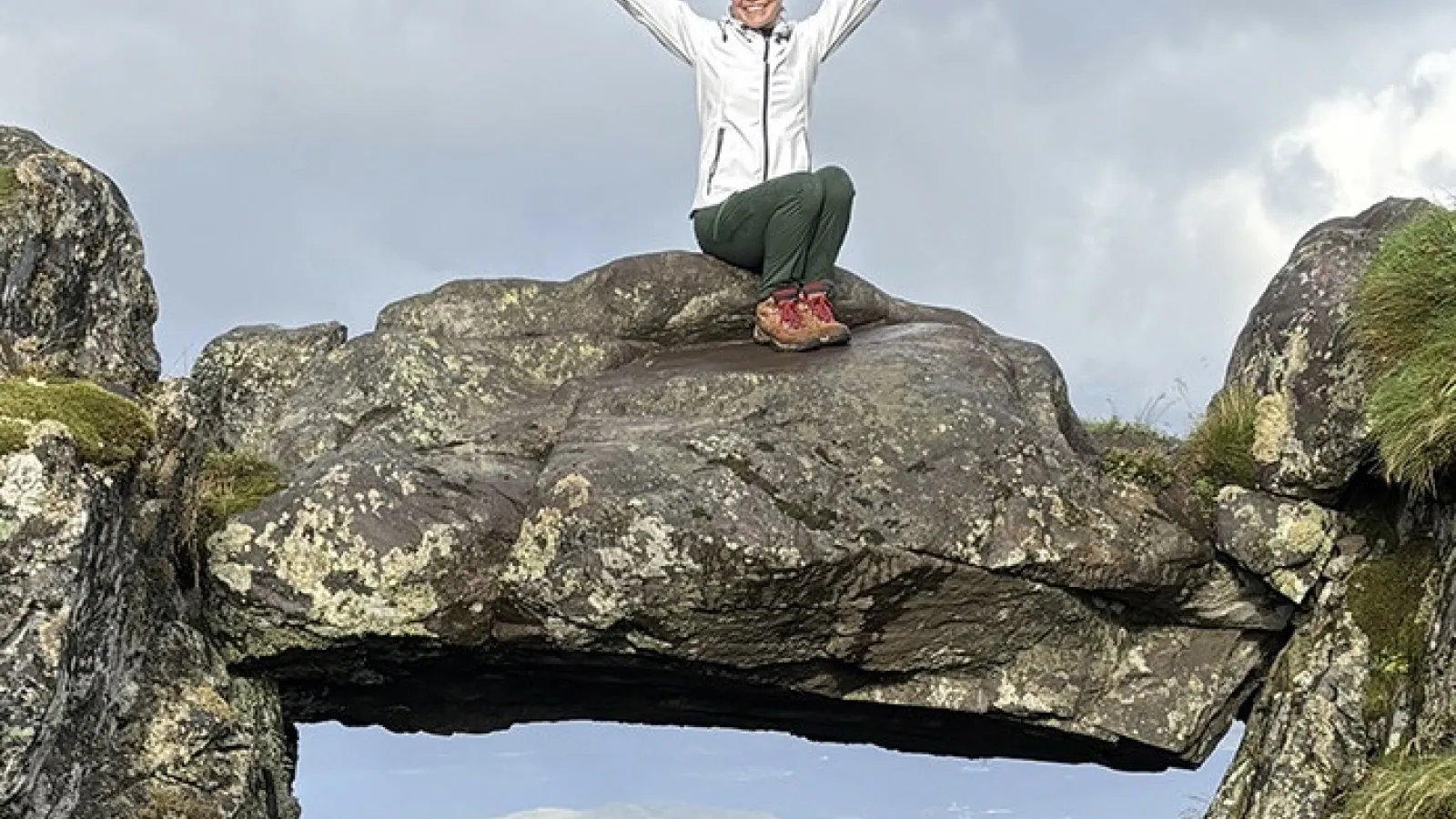 Erin Murray sitting on elevated rock structure 