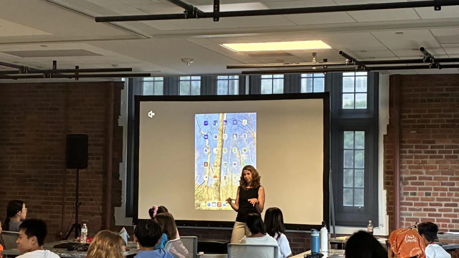 Laura Kubatko stands in front of projector screen at data science camp 2025
