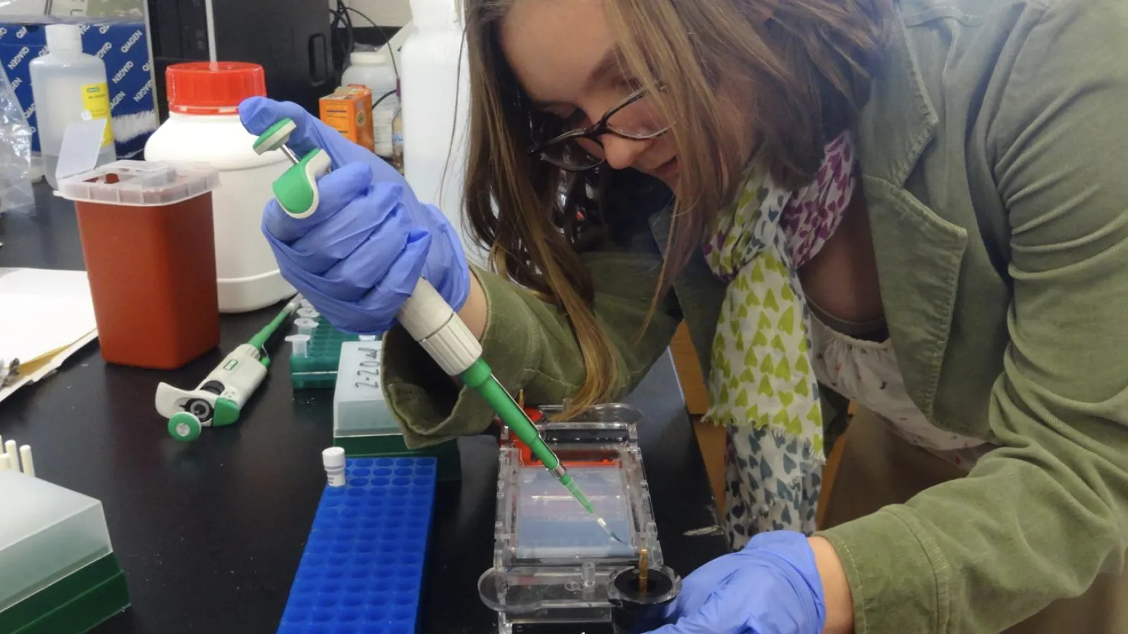 student bent over lab bench using pipeter