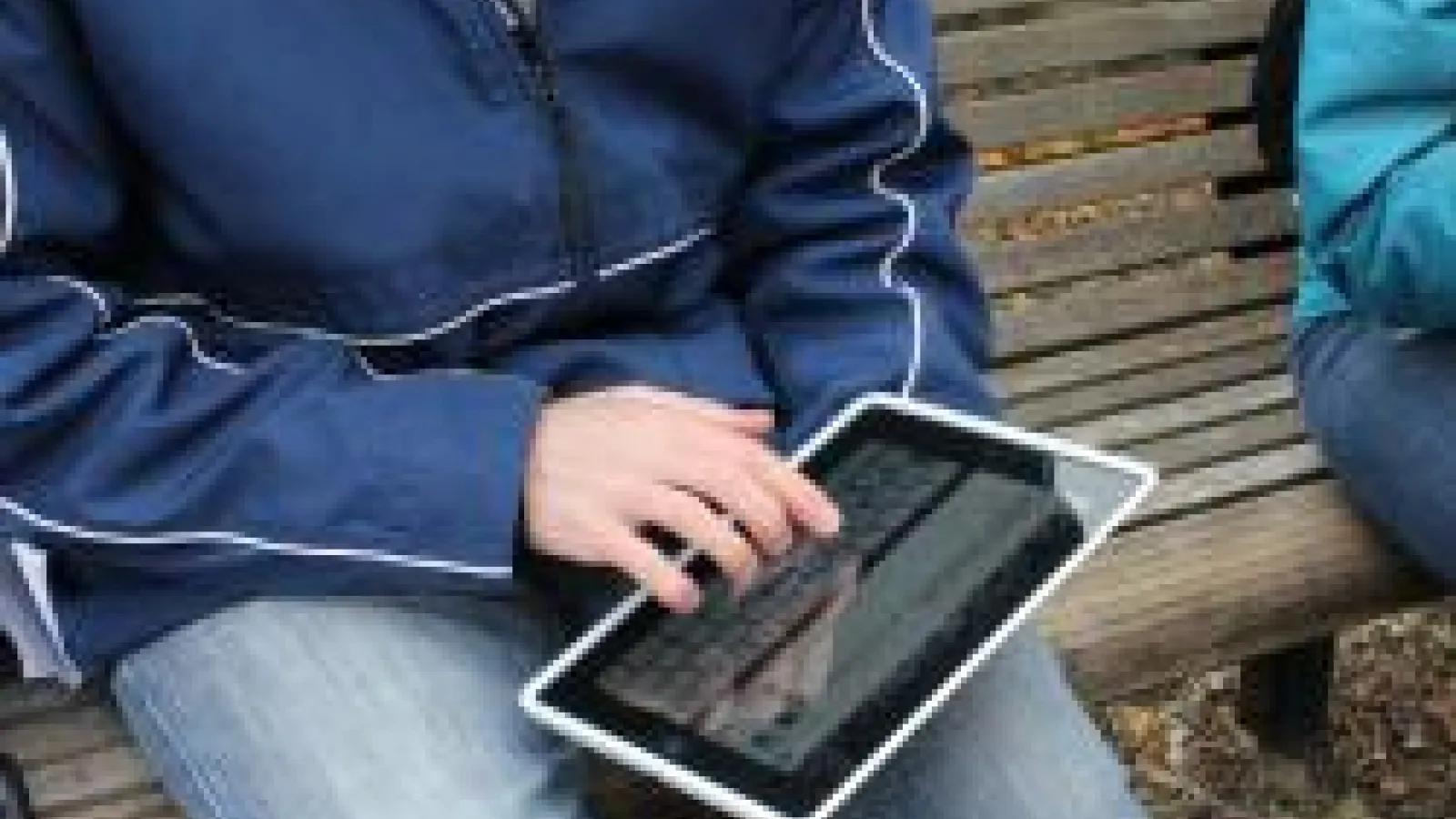 EEOB3320 Student using iPad on bench at the Learning Gardens