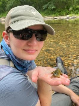 Maddie Schumacher holding a tadpole with legs