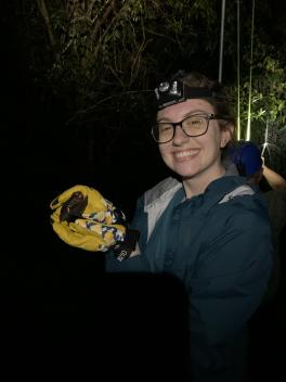 Haley Gmutza holds bat in the dark