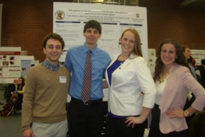 Erika Williams, Regan Hitt, Johnathan Hubbard, and Samantha Witchey in front of research poster at Denman