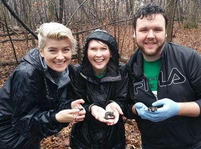 members of herpetology class holding salamanders