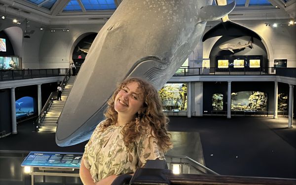 Chloe kenyon standing in front of whale model suspended from ceiling