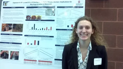 Bailey Gensheimer in front of poster at Denman