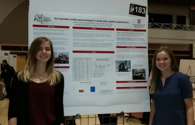 Sophie & Maddie in front of research poster at Denman Undergraduate Research Forum