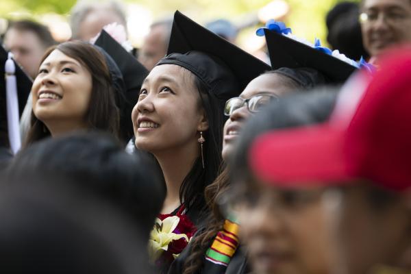 graduates at commencement looking up