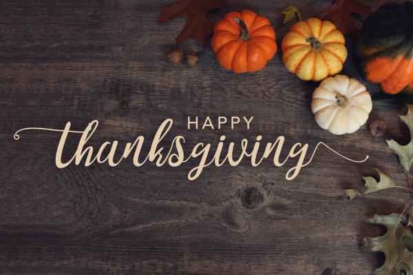 Happy Thanksgiving - variety of pumpkins and oak leaves on walnut board