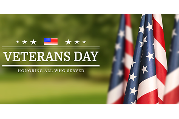 Veterans Day - Honoring all who served - 3 flagpoles with American flags on green landscape