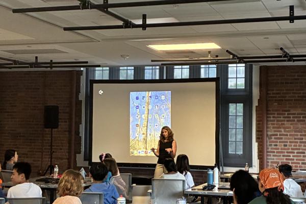 Laura Kubatko stands in front of projector screen at data science camp 2025