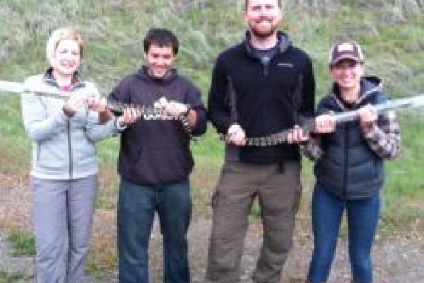 matt holding and 3 students hold 2 large snakes