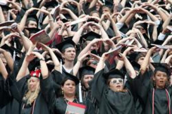 Graduates form “O” with their arms at the end of Carmen Ohio