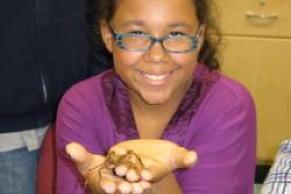 Student holding arthropod in hands