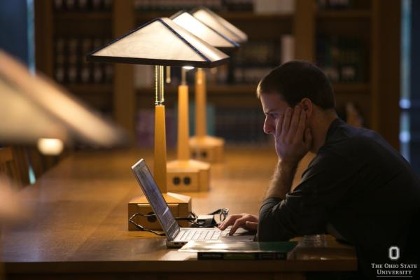 student studying  by lamplight in library