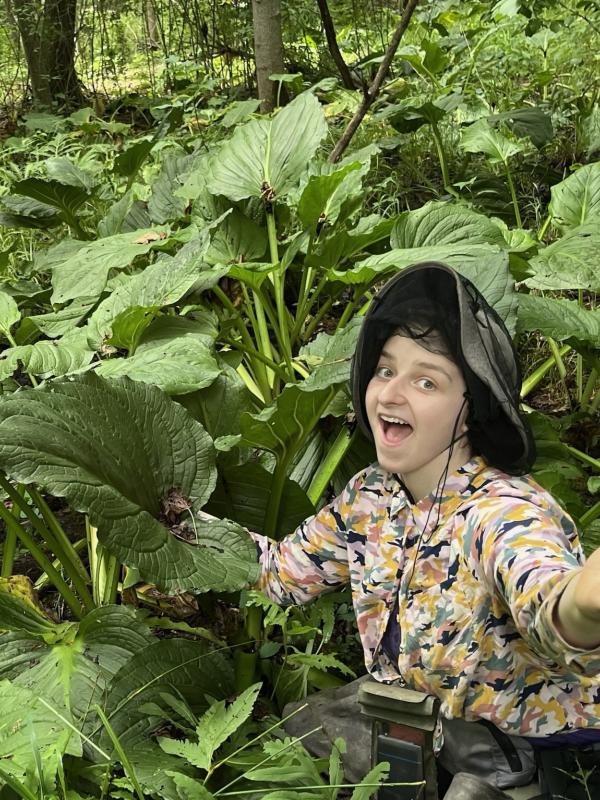 Grace Gutierrez sitting in skunk cabbage patch