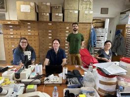 members of the Serb lab seated around a table in a collection at the Museum of Natural History, Paris, France