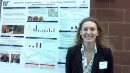 Bailey Gensheimer in front of research poster at Denman Undergraduate Research Forum