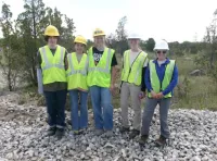 Ethan, Ayla, Ava, Jenny Finfera from USFWS and Amber Bellamy from USFWS outdoors in reflective vests and hard hats